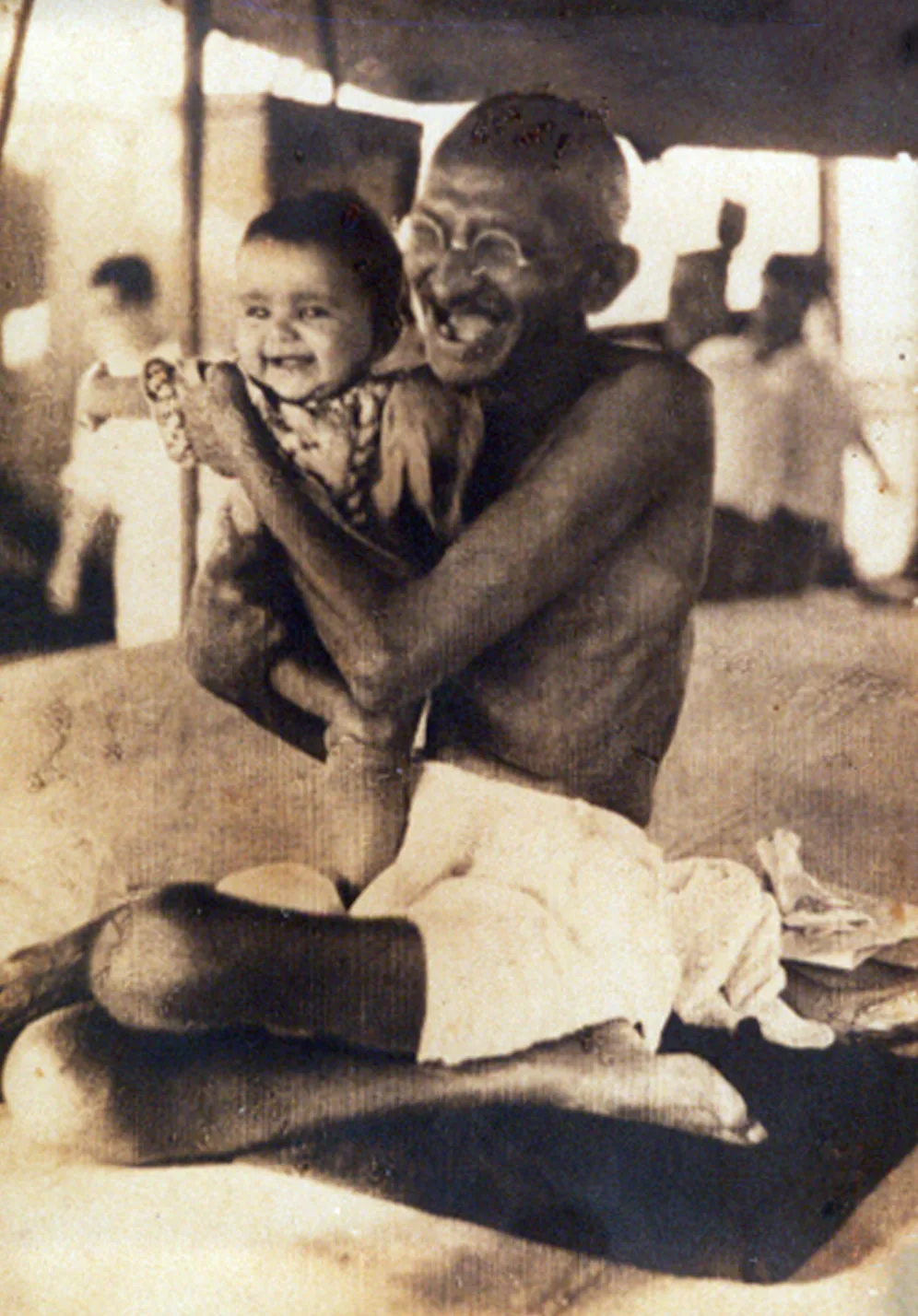 Mahatma Gandhi enroute by ship to the second Round Table Conference in London 1931 playing with baby Aziz Fatima, daughter of Shuaib Qureshi. The picture was published with the hea…